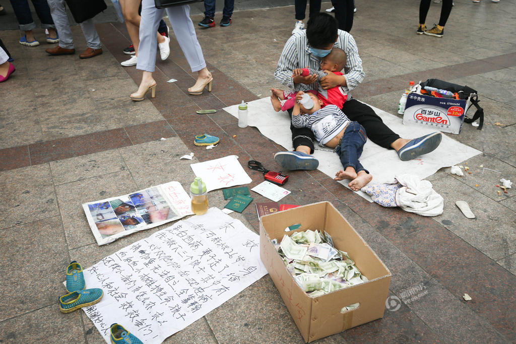 男人用铁链拴住双胞胎在北京一地铁口乞讨