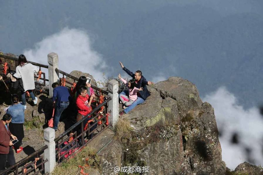 峨眉山旅客带孩子翻越峭壁围栏摄影 让人捏把汗